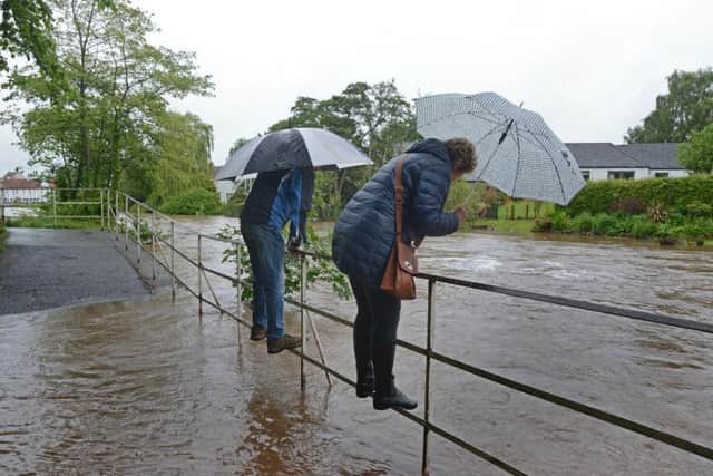 One pair stand on railings above the floodwater. Pic: Jon Savage