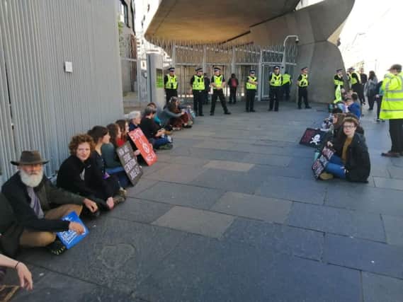Extinction Rebellion protestors glue themselves to sites around the Parliament building at Holyrood