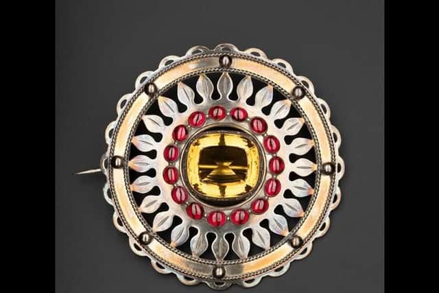 A silver plaid brooch set with a cairngorm in the centre and a ring of sixteen carbuncles round it, which worn by the chiefs of Clanranald in the mid-19th century.