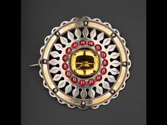 A silver plaid brooch set with a cairngorm in the centre and a ring of sixteen carbuncles round it, which worn by the chiefs of Clanranald in the mid-19th century.