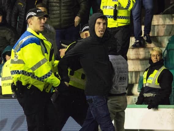 Mack being lead away by police after running onto the park and confronting James Tavernier