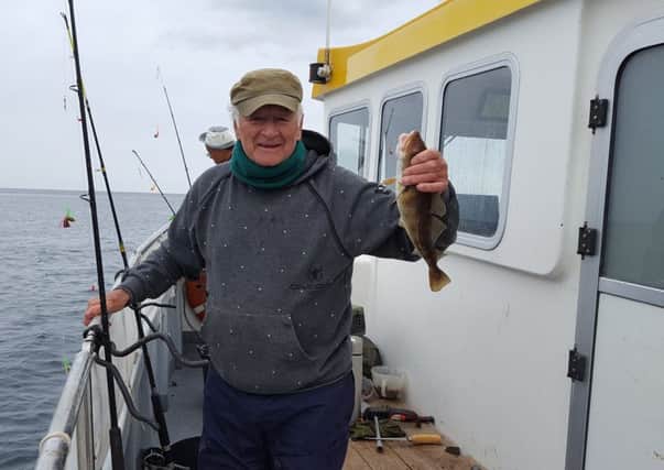 Alex Keenan aged 80 and a regular on board Sagittatius shows one of his haul of cod. Pic: Nigel Duncan Media