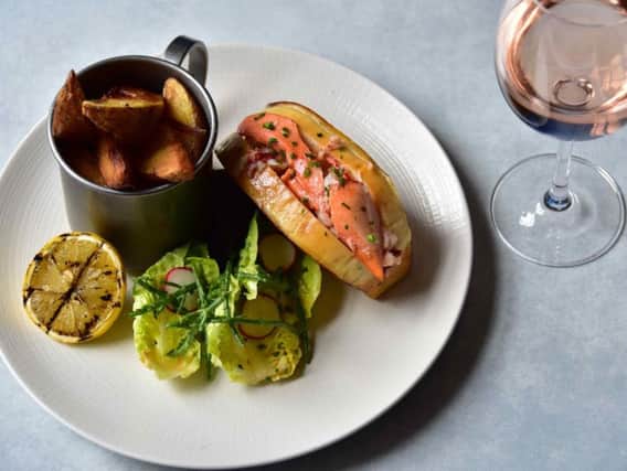 The Scottish lobster is served in a roll, drizzled with lemon and herb butter, and served with hand-cut chips and a side salad.