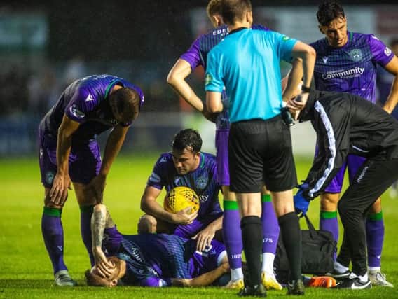 Hibs players check on Martin Boyle after he injured his knee. Pic: SNS
