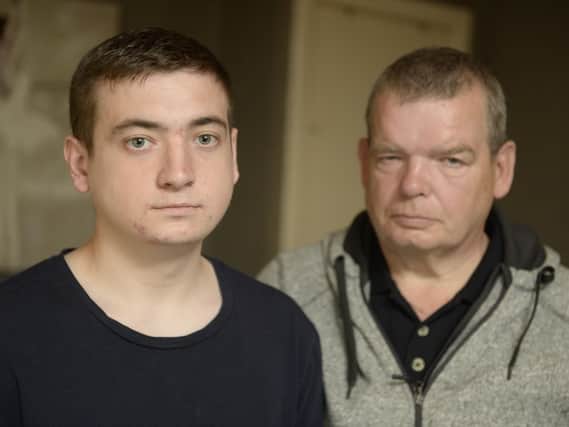 Anthony Gracey, 23, with dad  Joe Gracey, 60, at home in Easthall Place, Glasgow, after police mistakenly stormed the home with a drugs warrant. Picture: SWNS