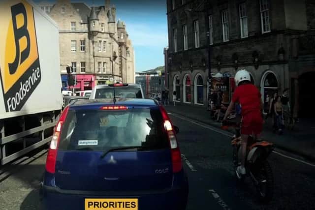 A rider overtakes traffic on an off-road bike in the Cowgate