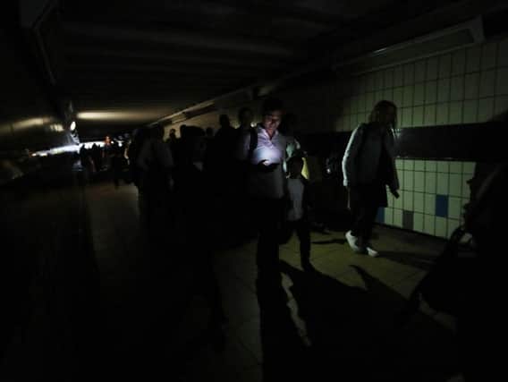 Commuters walk in darkness at London's Clapham Junction station. Picture: PA