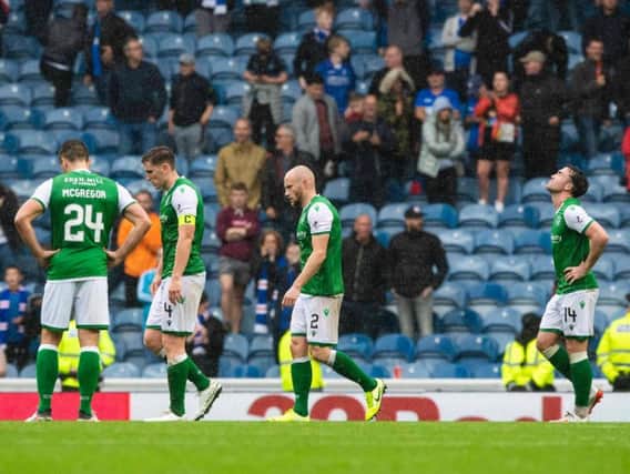 Hibs players hang their heads after the 6-1 thumping at Ibrox. Picture: SNS