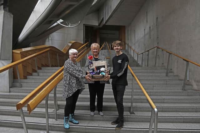 Gillain Semple (left) with Christine Grahame (centre) and her son Rory Semple as she became the five millionth visitor to the Scottish Parliament since the building opened in 2004. Picture: Andrew Cowan