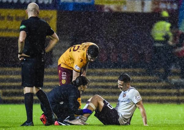 Hearts' Jamie Walker is treated by the physio at Fir Park