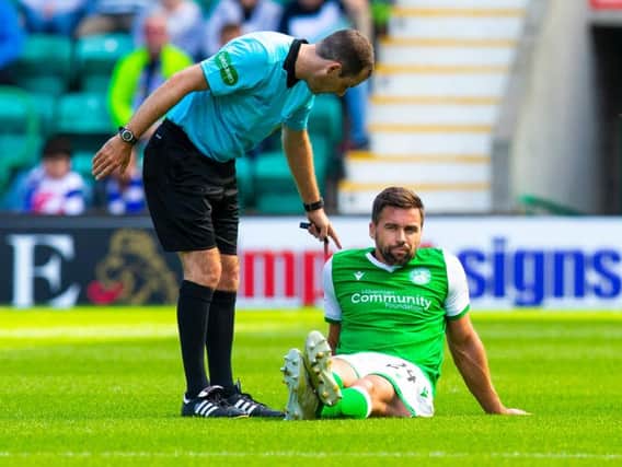 A disconsolate Darren McGregor sits on the Easter Road turf after suffering the abdominal injury which has ruled him out for several weeks.