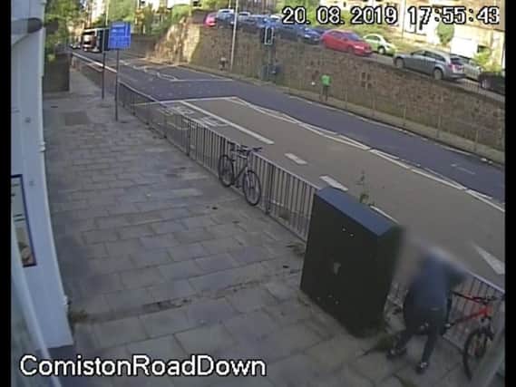 The thief uses bolt cutters to break the bike's lock