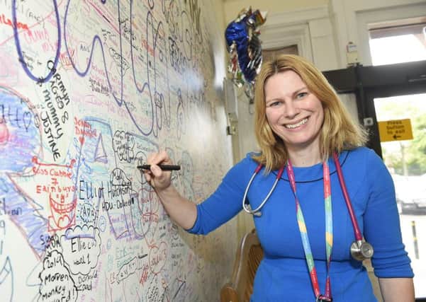Mairi Stark, a member of the Royal College of Paediatrics and Child Health and the lead for general paediatrics at the new Sick Kids Hospital, is pictured signing the wall in the old hospital ahead of the move. Picture: Greg Macvean