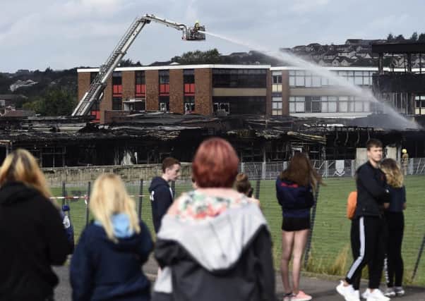 Firefighters continue to hose down Woodmill High School in Dunfermline. Picture: Lisa Ferguson