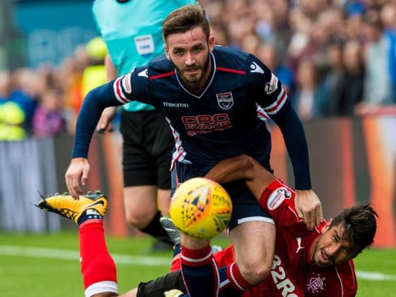 Jason Naismith rampages past Eduardo Herrera during a Ross County - Rangers match in Dingwall