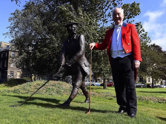 Alistair Campbell, current captain of the Honurable Company of Edinburgh Golfers, with the statue of John Rattray