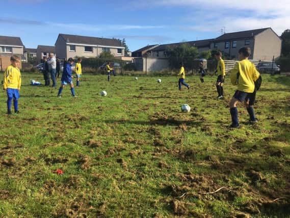 Kids attempt to play football on a badly maintained pitch at Buckstone.