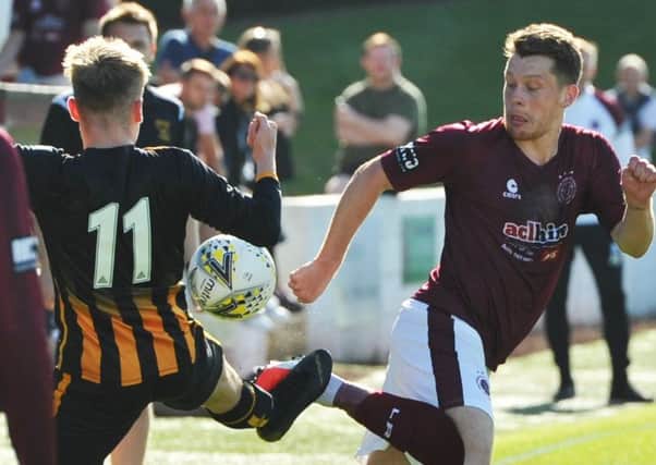 Huntly's Nathan Meres and Linlithgow's Ross Barbour challenge for the ball