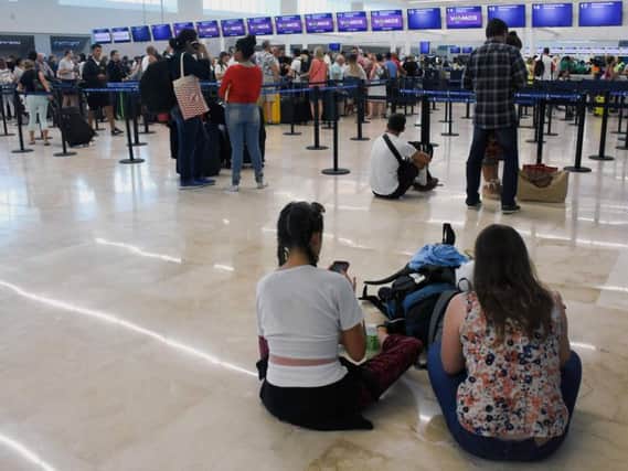 Passengers wait for news in Cancun airport.
