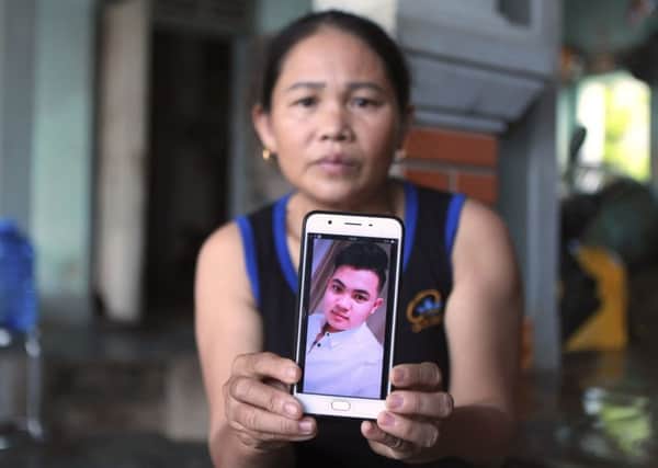 Hoang Thi Ai holds a picture of her son Hoang Van Tiep, feared among the 39 migrants who died in a lorry in Essex (Picture: Hau Dinh/AP)